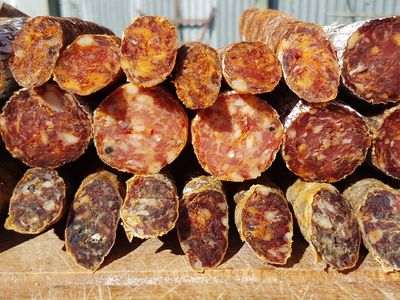 A selection of homemade salami, showcased cross-sectionally, highlighting their rich textures and colors.